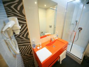 a bathroom with an orange sink and a shower at City Park Hotel by CHM in Bila Tserkva