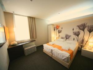 a hotel room with a bed and a television at City Park Hotel by CHM in Bila Tserkva