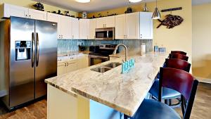 a kitchen with a granite counter top and stainless steel refrigerator at Put-in-Bay Waterfront Condo #209 in Put-in-Bay