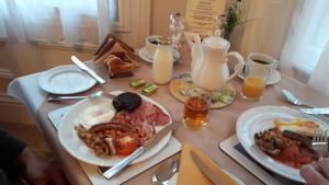 a table with plates of breakfast food and drinks at Boulmer Guest House in Whitby