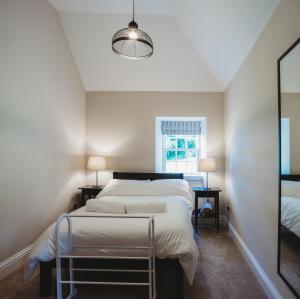 Un dormitorio con una cama grande y una ventana en Orchard Cottage en St Andrews