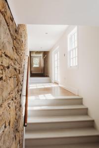 a hallway with stairs and a stone wall at Orchard Cottage in St. Andrews