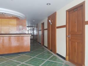 un corridoio vuoto con porte in legno e piastrelle verdi di Phi Phi Hotel a Phi Phi Don Altre 12 foto