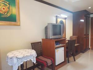 un soggiorno con TV, tavolo e sedie di Phi Phi Hotel a Phi Phi Don
