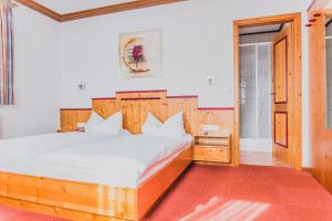 a bedroom with a large bed with a wooden headboard at Landgasthof Schwarzer Adler GbR in Dietenhofen