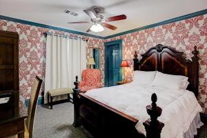 a bedroom with a bed and a ceiling fan at Sara's Inn on the Boulevard in Houston