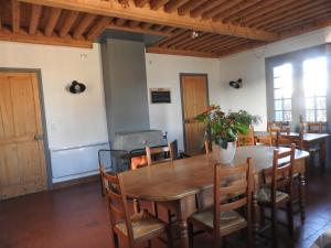 a dining room with a wooden table and chairs at Domaine de Laverchère in Pommiers-en-Forez