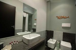 y baño con lavabo, aseo y espejo. en Two Sisters Suites, en Nápoles