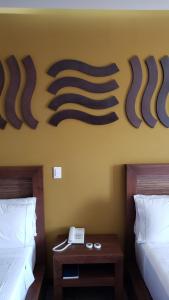 a hotel room with two beds and a phone on the wall at Terrass Hotel Zamora in Zamora de Hidalgo