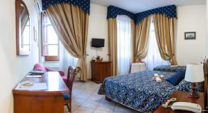 una camera con letto, tavolo e scrivania di Hotel Il Cavalier D'Arpino ad Arpino