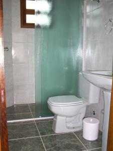 un baño con inodoro y lavabo en Kitnets Park Verde, en Peruíbe