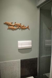 baño con dispensador de papel higiénico y una rama en la pared en Two Sisters Suites, en Nápoles