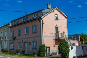 un gran edificio rosa en el lateral de una calle en Suit Brais en Barreiros