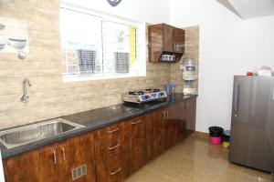 a kitchen with a sink and a stainless steel refrigerator at Dunhill Premium Service Apartment in Bangalore