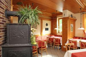 un restaurante con mesas, sillas y una planta en Hotel & Gasthof Zur Linde en Kipfenberg