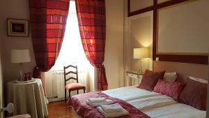 a bedroom with a bed with red curtains and a window at Villa Branca Jacinta in Sintra