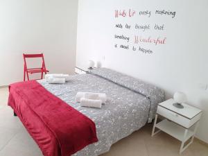 sypialnia z łóżkiem z cytatem na ścianie w obiekcie Casa Genny w mieście Garda