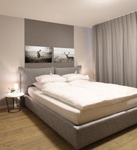 1 dormitorio con 1 cama grande con sábanas blancas en Rückersbacher Schlucht, en Johannesberg
