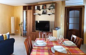una sala da pranzo con tavolo, sedie e TV di Casa Genny a Garda
