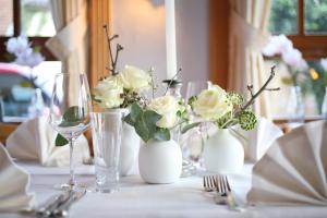 een tafel met witte vazen met witte bloemen erop bij Rückersbacher Schlucht in Johannesberg