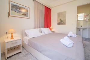 a bedroom with a white bed with two towels on it at Prince Studios in Sami