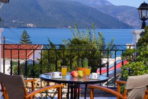 a table with fruit on a balcony with a view of the water at Prince Studios in Sami