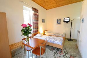 a bedroom with a bed and a table with a vase of flowers at Armonia Central in Loutra Edipsou