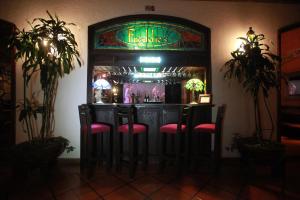 a bar with pink stools in a room at Hotel Montetaxco in Taxco de Alarcón
