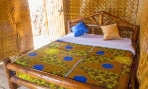 a bed with a quilt on it in a room at OM Hostel Bunyonyi in Kabale +95 photos