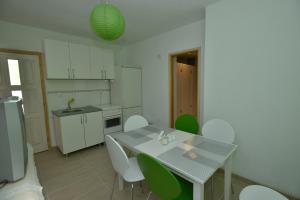 a kitchen with a table and some green chairs at Hostel Bojo in Mostar