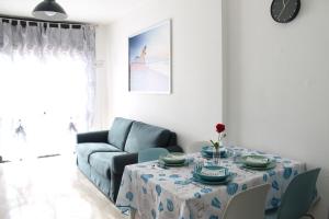 un soggiorno con tavolo e divano di BlueHoliday a Piombino