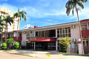 a building with palm trees in front of it at Hotel Taiyo in Caldas Novas