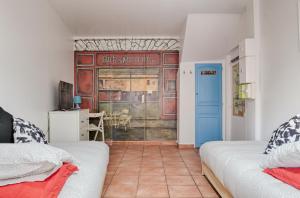 a room with two beds and a door with a table at Studio Panier 2000 in Marseille