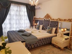 a bedroom with a large bed and a chandelier at Hotel Dalia - Bankya in Bankya