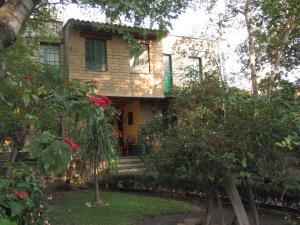 an old house with trees and flowers in front of it at Casa del Retoño in Guadalajara