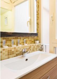 y baño con lavabo y espejo. en Vittoria Suite, en Roma