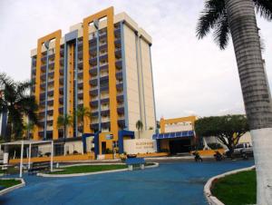 カルダス・ノバスにあるCaldas Novas Eldorado Flat - Piscinas Quentes Maravilhosasのヤシの木がある黄色と白の大きな建物