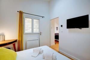 una camera da letto con un letto e una televisione su una parete di Les Halles et Hauteurs by Cocoonr a Bordeaux