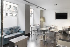 a living room with a couch and tables and a tv at Petit Palace Plaza España in Madrid