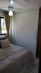 1 dormitorio con 1 cama y ventilador de techo en APT 2 quartos da Doris Monteiro, en Maceió