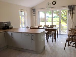 Una cocina y un comedor con mesa y sillas. en Eight ball house, en Southburgh