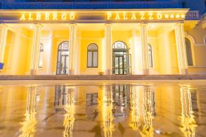 a building with a reflection in a pool of water at Albergo Palazzo in Santa Cesarea Terme