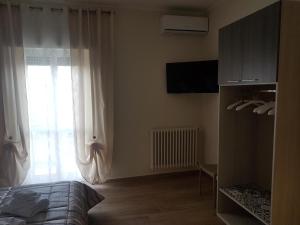 a bedroom with a bed and a window with curtains at Casa Vacanze Derica in Matera