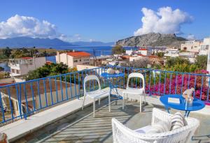 balcón con mesas y sillas y vistas a la ciudad en Aeginia 1- Breathtaking sea view house in Perdika, en Perdika