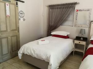 ein Schlafzimmer mit einem weißen Bett und einem Fenster in der Unterkunft Kalahari Rus in Upington