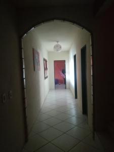 einen Flur, der zu einem Zimmer mit weißen Wänden und Fliesenböden führt in der Unterkunft Casa Majorlandia in Majorlândia