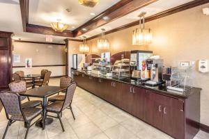 a restaurant with a counter with a table and chairs at Red Lion Inn & Suites Mineral Wells in Mineral Wells
