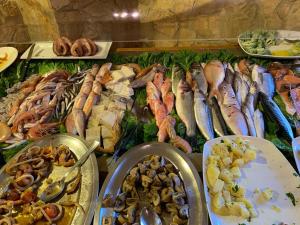 un buffet pieno di diversi tipi di frutti di mare e verdure di Gisira Apartments Al Borgo a Catania