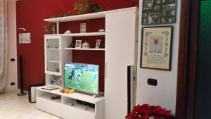 een woonkamer met een tv op een witte plank bij BBCinecitta4YOU in Rome