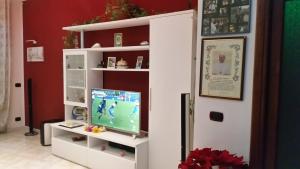 sala de estar con TV en un estante blanco en BBCinecitta4YOU, en Roma